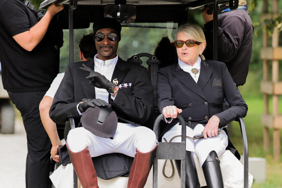 03 August 2024, France, Versailles: Olympics, Paris 2024, equestrian sport, dressage, team, final, US rapper Snoop Dogg and Martha Stewart ride a golf cart. 