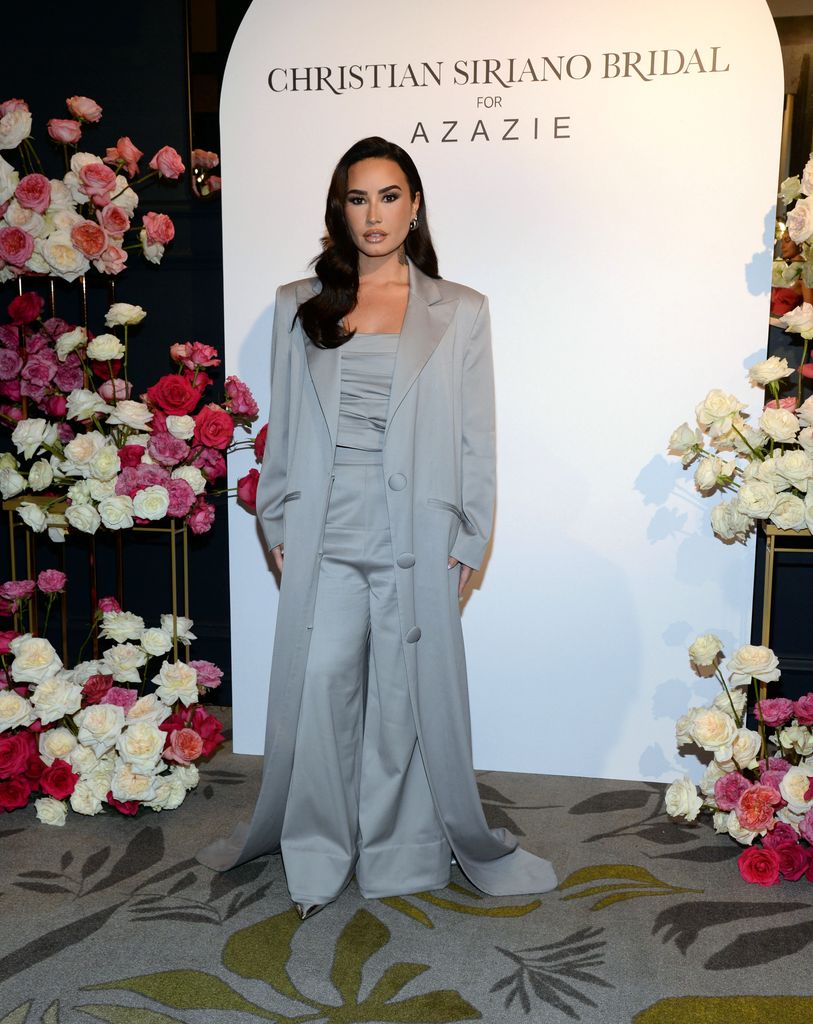 Demi Lovato in grey trousers, top and long jacket