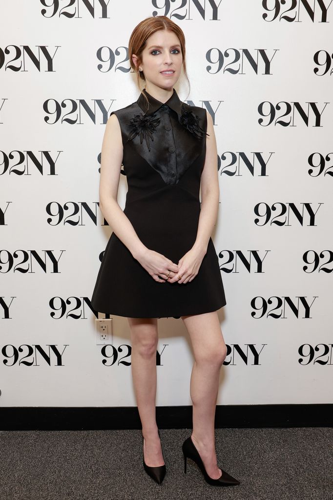 Anna Kendrick poses in black satin mini dress