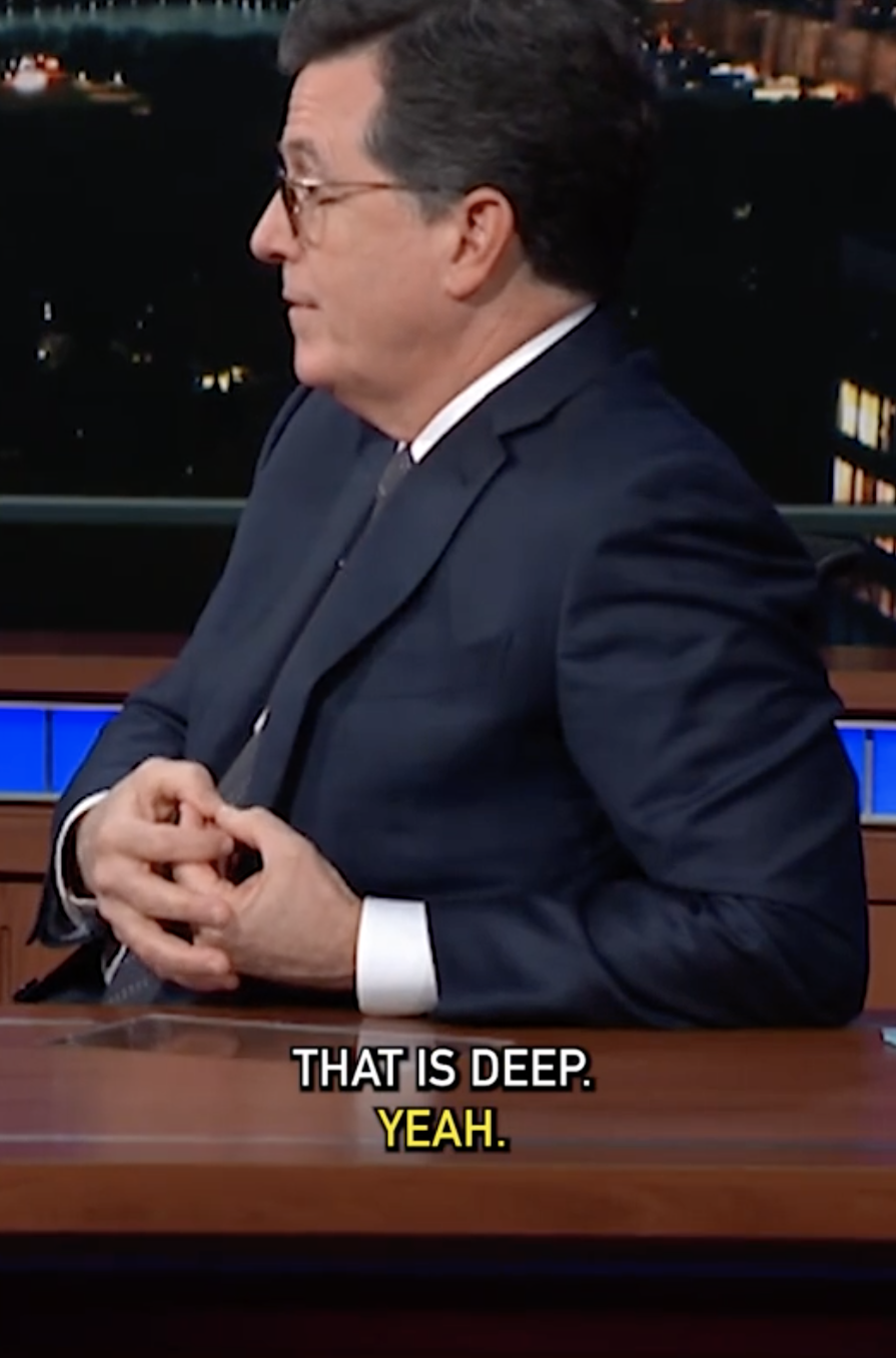 Man in a suit, seated at a desk on a talk show set, saying "That is deep. Yeah."