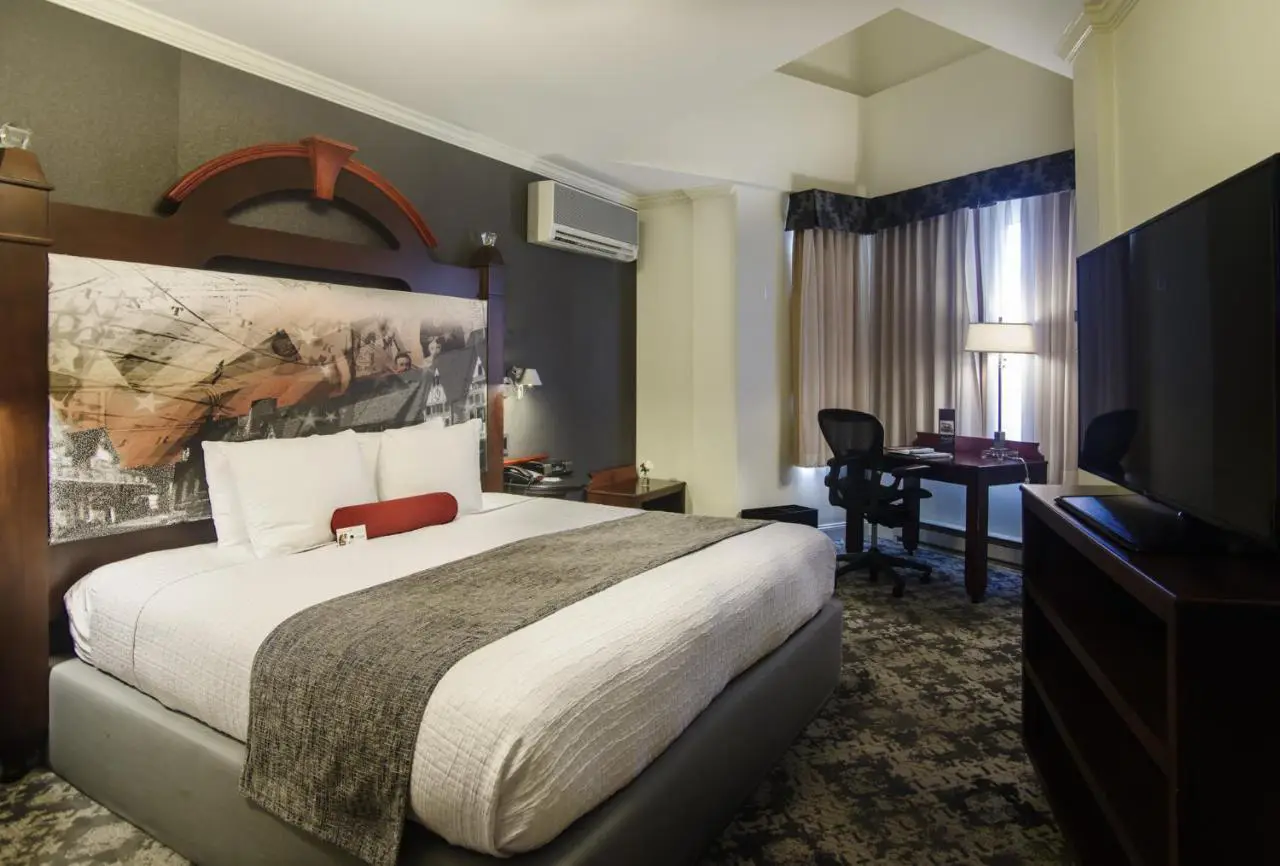 A cozy and modern guest room at Chestnut Hill Hotel, featuring comfortable bedding and a work desk.