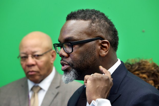 Chicago School Board President Mitchell Johnson, left, looks on as Chicago Mayor Brandon Johnson speaks to the media after a tour of Collins Academy High School, Oct. 25, 2024. (Terrence Antonio James/Chicago Tribune)