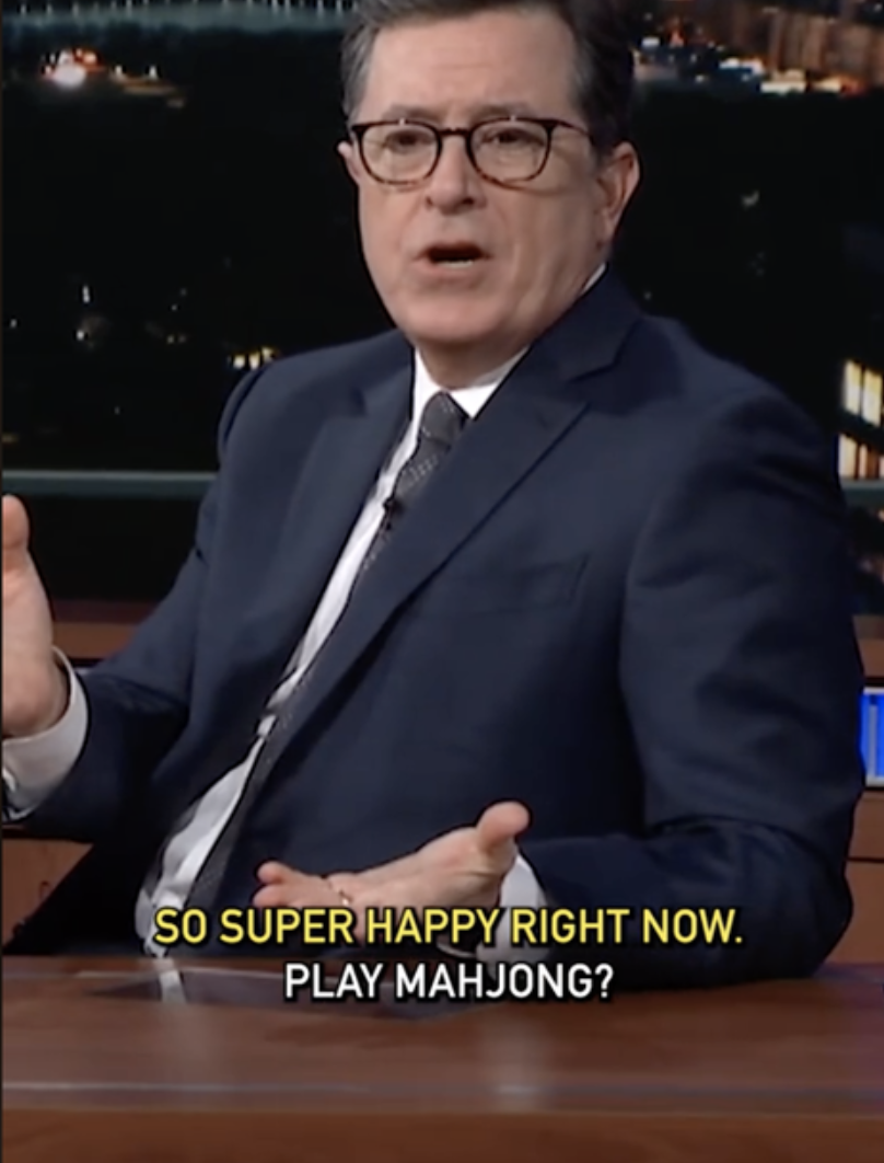 A man in a suit on a talk show set with subtitles: 